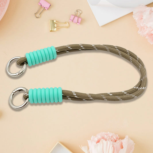 A phone with a vibrant multi-colored phone wrist strap attached, held securely.