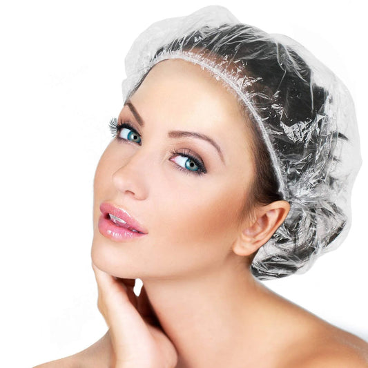 A stack of individually wrapped disposable shower caps, ready for use.